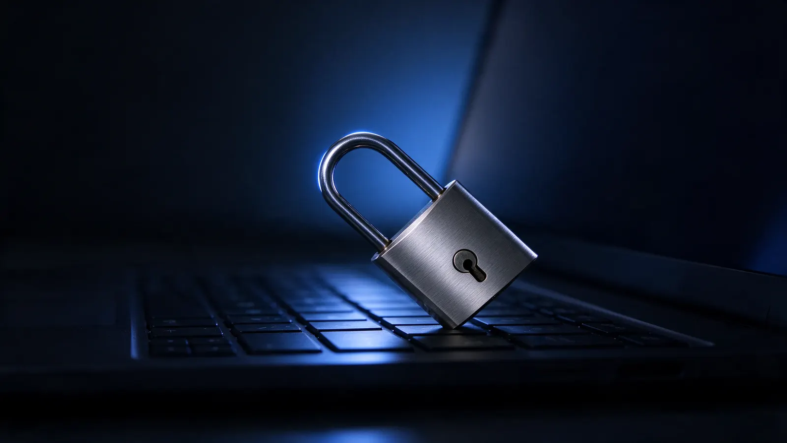 Cadeado aberto apoiado sobre o teclado de um notebook