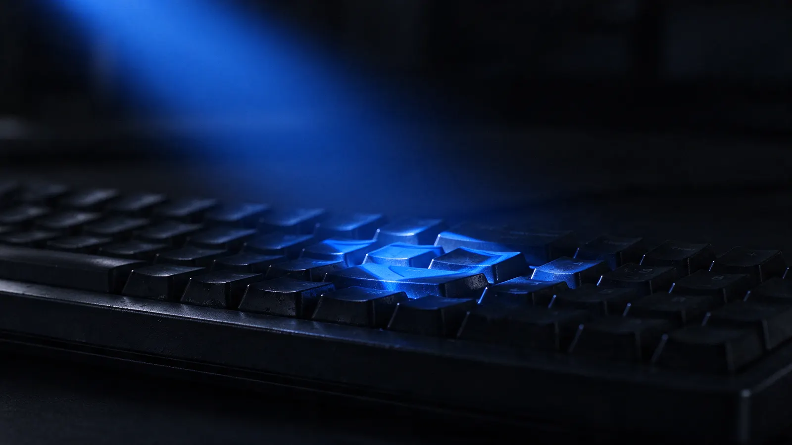 Teclado mecânico em close com reflexo azul em forma de escudo
