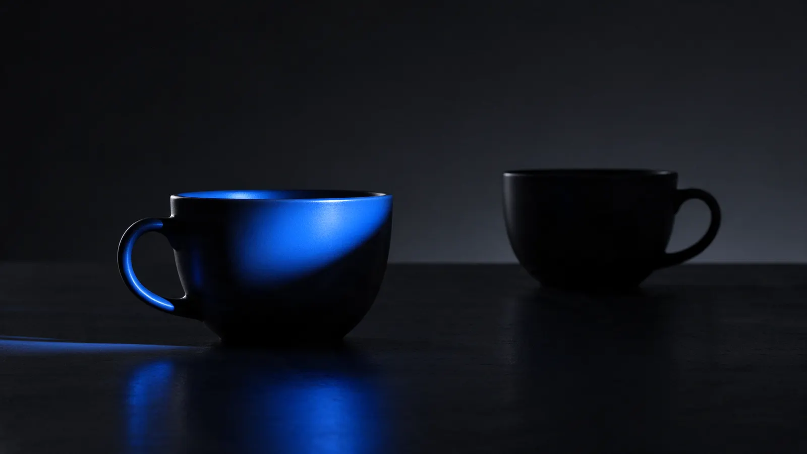 Duas xícaras iguais, só uma iluminada em azul