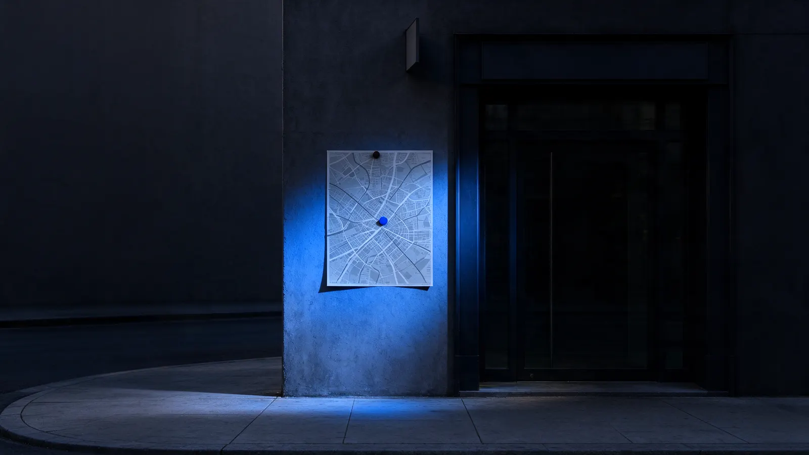 Fachada escura de uma loja à noite com um mapa de ruas impresso preso na parede, iluminado por uma luz azul, ao lado da porta de vidro